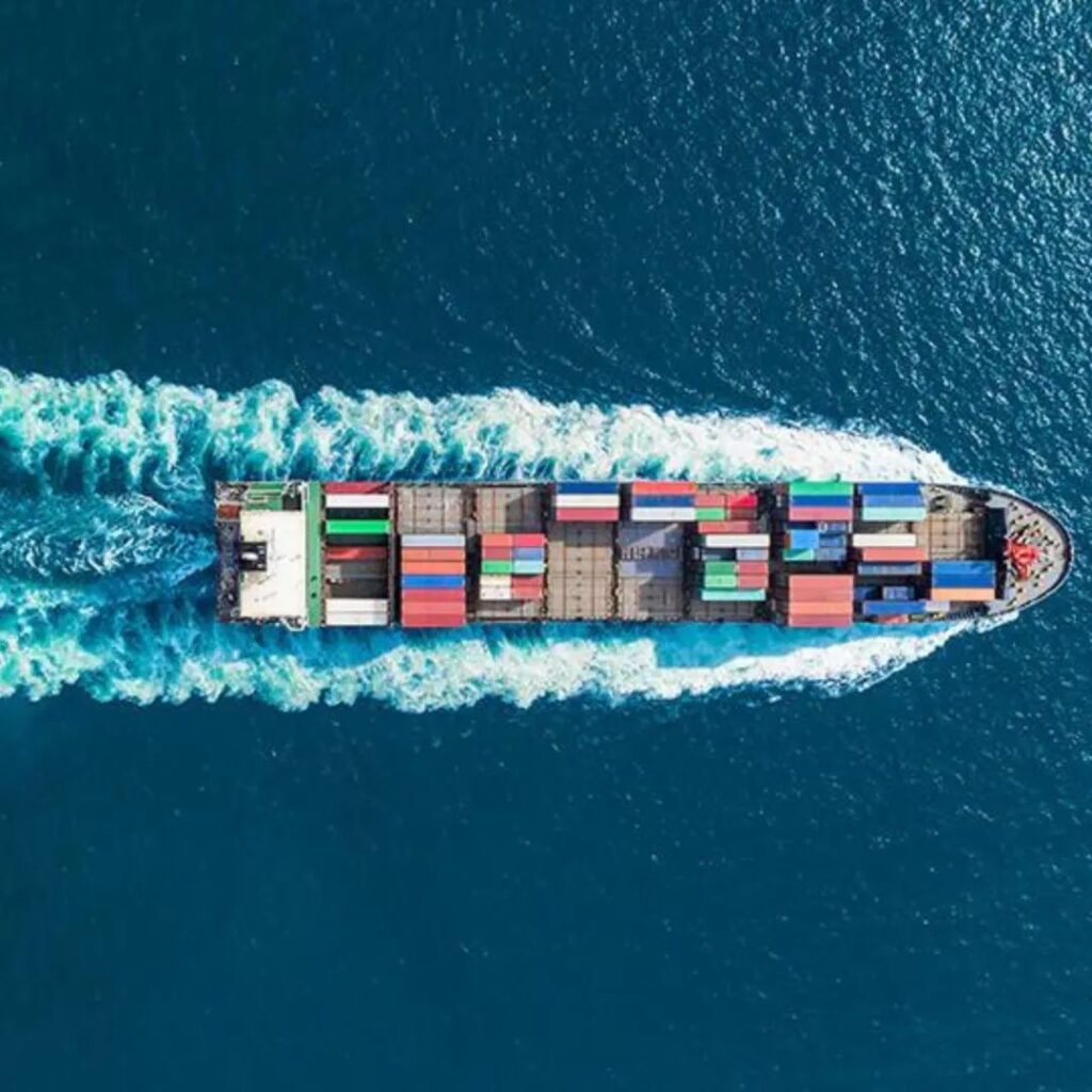 Aerial view of a cargo ship loaded with containers on a sunny day at mid-sea